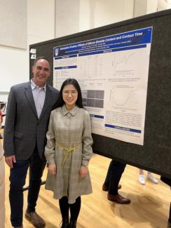 Dr. Carvalho and Vivian standing in front of a research poster